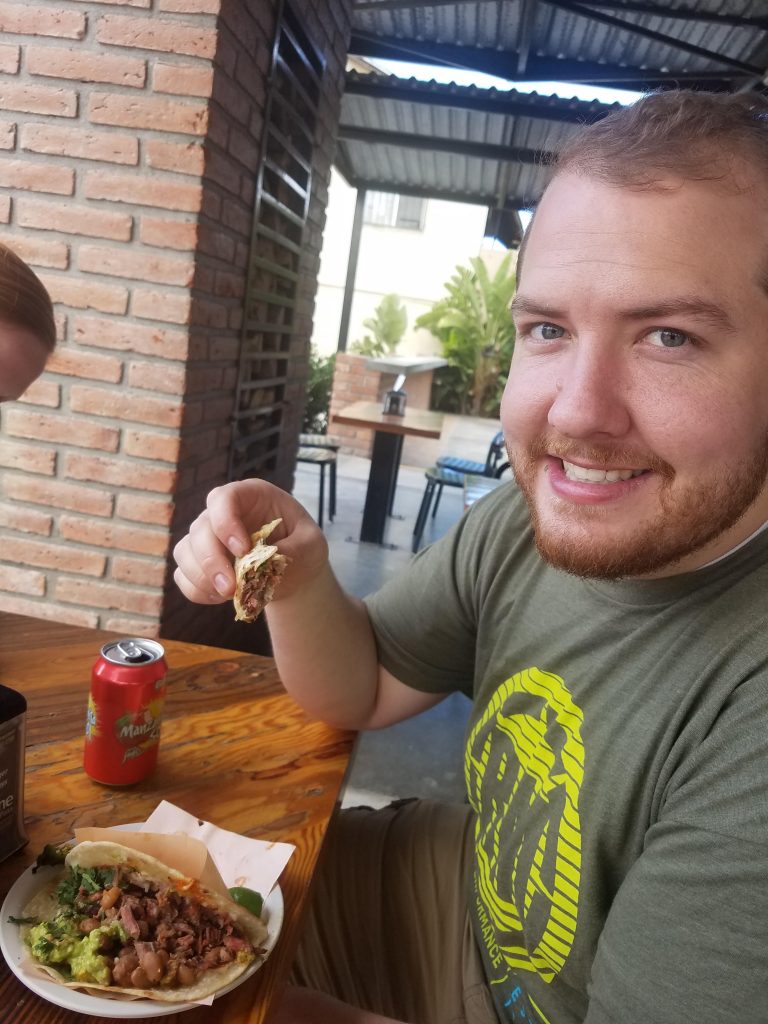 A man eating a Carne Asada taco from Tacos el Yaqui