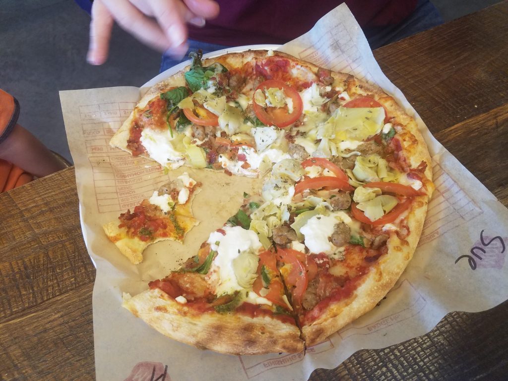 Pizza with cheese, marinara sauce, tomatoes, basil, ricotta cheese, mushrooms and artichokes at mod pizza in Ogden Utah  