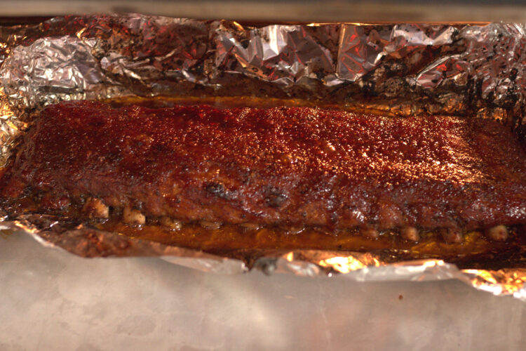 Oven baked BBQ pork ribs with caramelized BBQ sauce on top.
