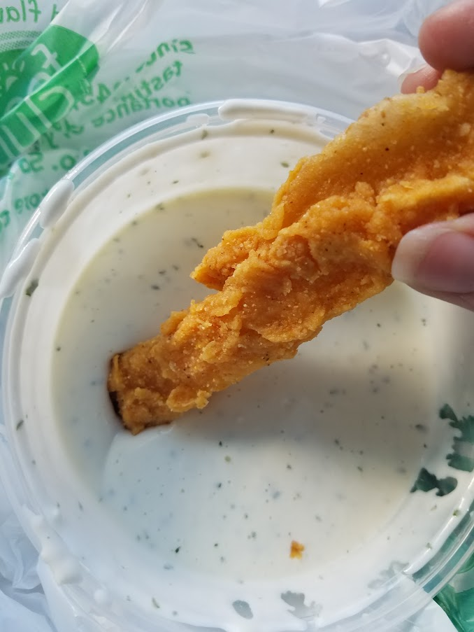 Dipping a potato log into Ranch dressing.