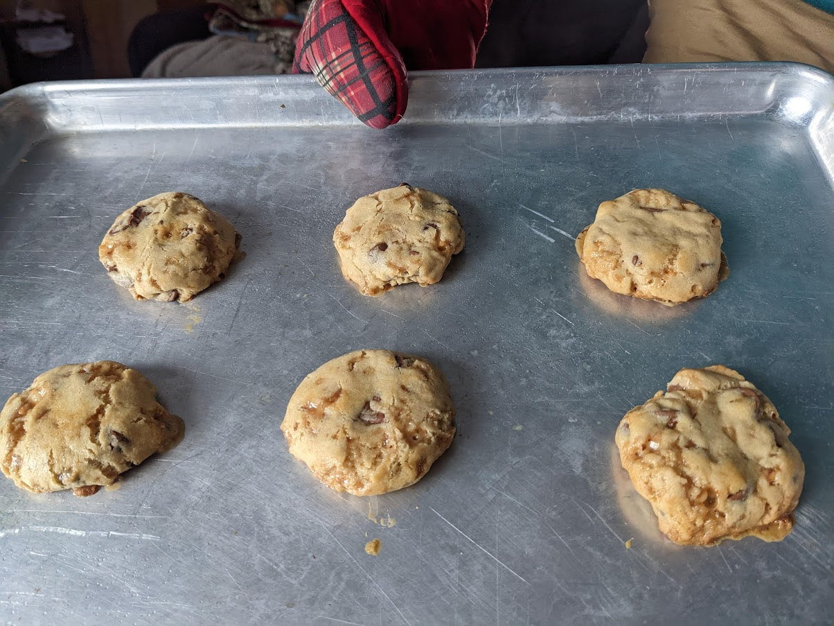 six chocolate chip cookies on a cookie sheet