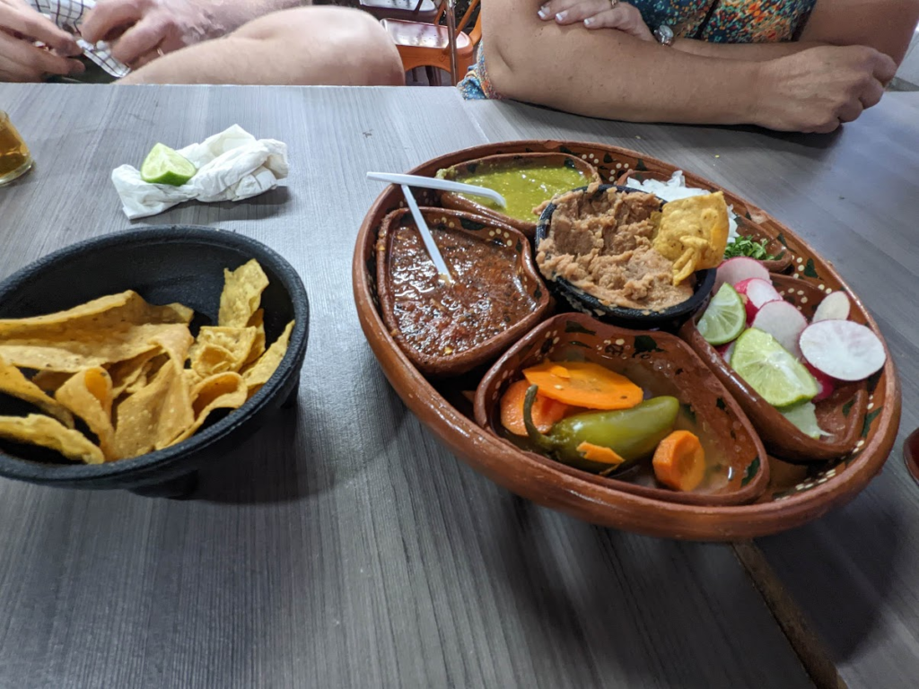 A platter with refried beans, red salsa, green salsa, carrots, jalapenos, radishes, limes and tortilla chips from La Morenitas in Rosarito Mexico 