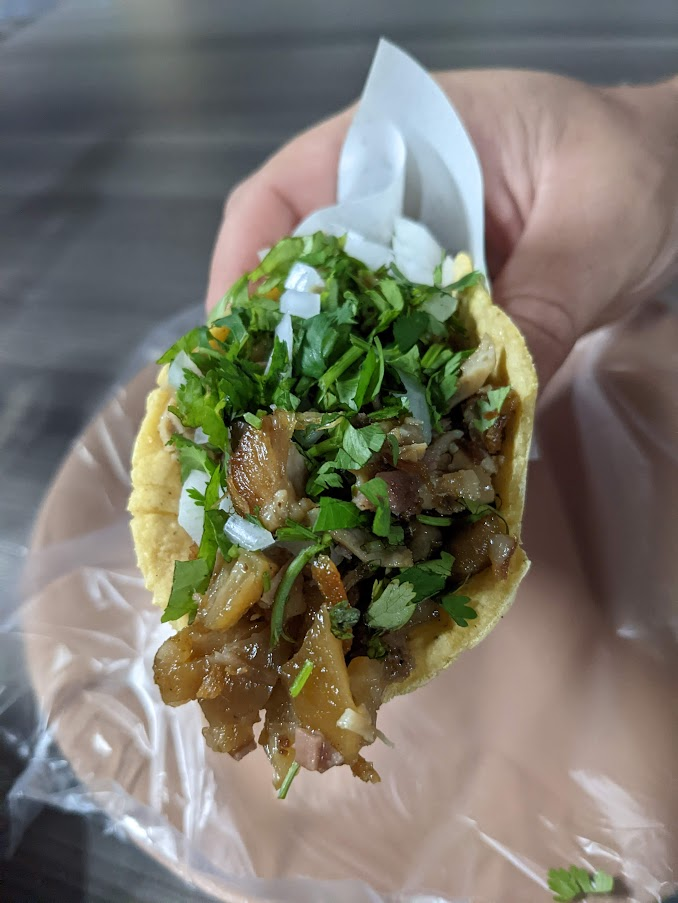 A hand holding a taco from La Morenitas in Rosarito Mexico